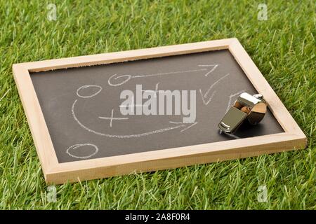 Fussball sport Schiedsrichter chrom Pfeife mit spiel strategie Zeichnung Blackboard auf Gras Hintergrund-selektiven Fokus, selektiver Fokus Stockfoto