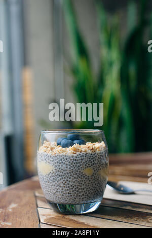 Blueberry yoghurt Parfait mit Müsli, Hafer und Chia Samen in ein Glas auf weissem Holztisch. gesundes Frühstück. Nach oben Schließen Stockfoto