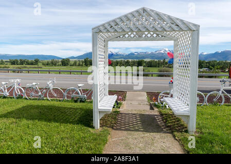 Zaun mit alten Fahrrädern und Arbor vor einem Haus im Prairie City, Oregon. Stockfoto