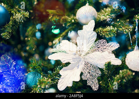 Geschmückten Weihnachtsbaum. Dekoriert Weihnachten white flower auf unscharfe, Schaumwein und Fee Hintergründe mit Weihnachtsbaum. Stockfoto