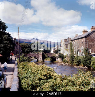 Steinerne Brücke über den Fluss Colwyn in dem Dorf Beddgelert, Snowdonia National Park, Gwynedd, Wales 1964 Stockfoto