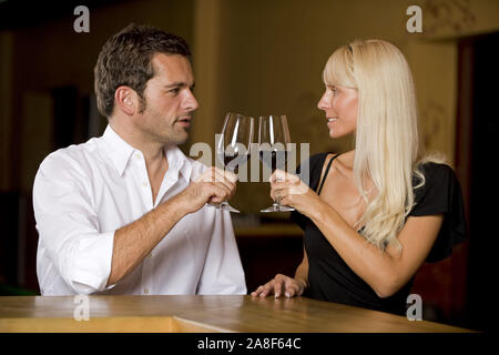 Mann und Frau Artikel an der Bar und trinken ein Glas Rotwein, HERR: Ja Stockfoto