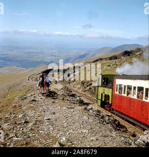 Eisenbahn Zug auf Mount Snowdon Mountain Railway Line und Menschen zu Fuß auf Llanberis Pfad in Snowdonia Wales UK 1958 Stockfoto