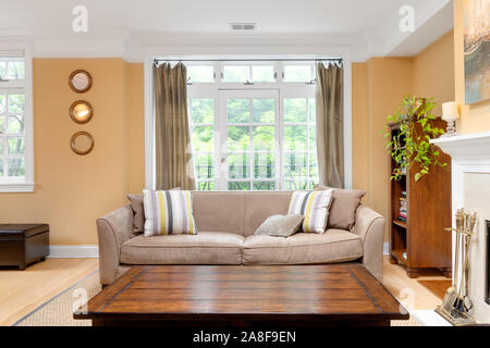 Ein gemütliches Wohnzimmer in der Innenstadt von Chicago Eigentumswohnung mit Kamin und neutrale, Sitzgelegenheiten, sowie gelbe Wände. Stockfoto