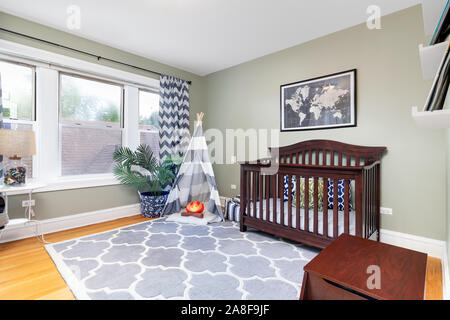 Ein Kind im Schlafzimmer mit einem dunklen farbigen Krippe und Tipi mit einem Kissen Lagerfeuer im Inneren. Stockfoto