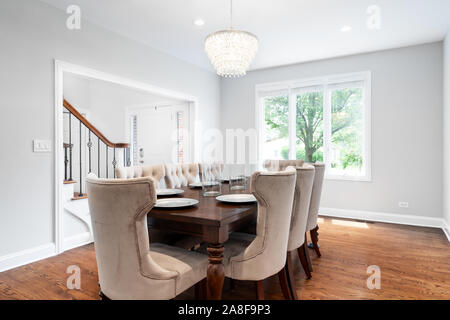 Ein luxuriöses Wohnzimmer mit einem Blick nach draußen. Dieses geräumige Bereich kann ein großer Tisch mit einem modernen Licht nach unten hängen über der Oberseite anbringen. Stockfoto