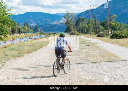 Penticton, British Columbia/Kanada - September 1, 2019: Mann auf Radtouren entlang der Penticton Fluss Kanal Trail, ein beliebter Weg Stockfoto