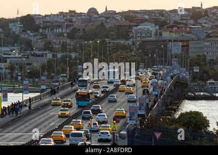 Fahrzeuge fahren durch Unkapani Brücke bei Sonnenuntergang Stunde. Front- und Rückansicht des Taxis, Autos und Busse. Stockfoto