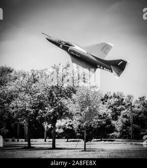Ein tief fliegenden vintage US Navy Blue Angels Flugzeug Banking über die Baumkronen in den USA Stockfoto