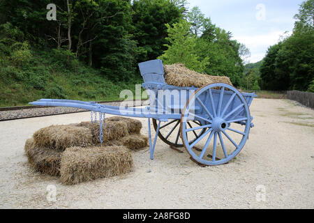 Blau Heuwagen und Heuballen, Ardèche, Frankreich Stockfoto