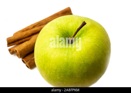 Green Apple mit Zimtstangen auf weißem Hintergrund Stockfoto