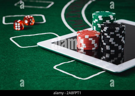 Online Poker und Casino Konzept. Poker chips und eine digitale Tabelle auf grünem Filz Stockfoto