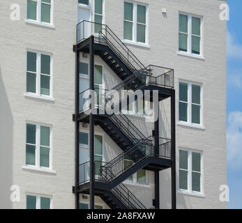 Ein Kontrast zwischen einem modernen schwarzen Eisen Feuer Flucht auf ein klassisches weißes Ziegelgebäude mit minimalistischen Akzente in Hattiesburg, MS, USA Stockfoto
