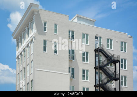 Ein Kontrast zwischen einem modernen schwarzen Eisen Feuer Flucht auf ein klassisches weißes Ziegelgebäude mit minimalistischen Akzente in Hattiesburg, MS, USA Stockfoto
