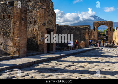 Blick auf die Via del Foro in Pompeji mit Bogen von Caligula und den Vesuv im Hintergrund. Pompeji, Italien, Oktober 2019 Stockfoto