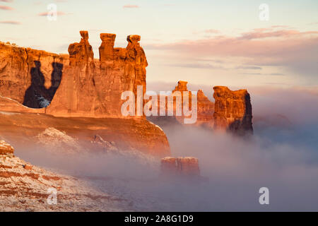 Nebel im Winter Dawn, Arches National Park, Utah. Drei Klatschbasen, Schafe Rock Stockfoto