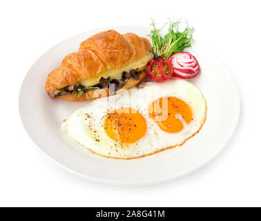 Frühstück mit Croissant sandwich innen Mozzarella und Rote eiche Salat Beilage mit gebratenen/Ei, schwarzen Pfeffer und Salz bestreuen Essen für ein Stockfoto