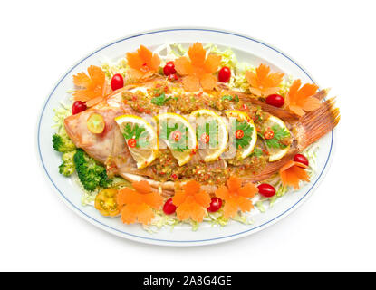 Gedünsteter Fisch (Tilapia Fisch) in Zitronensauce mit Thai würzige Soße oder Meeresfrüchte sauce Dekorieren mit geschnitzten Möhren Tomaten Gemüse Stil gesunde Nahrung, Stockfoto