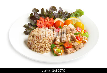 Brauner Reis mit Thunfisch Salat klare Soße gesundes Essen cleanfood Dekorieren geschnitzten Tomate, Zitrone in Scheiben schneiden und Blatt rote Eiche Seitenansicht isoliert auf weißem backgro Stockfoto