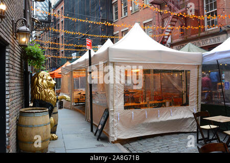 NEW YORK, NY - 05. Nov. 2019: Stone Street Restaurants richten Sie Zelte, die in den eine schmale Straße mit Kopfsteinpflaster im Herzen des Finanzviertels. Stockfoto