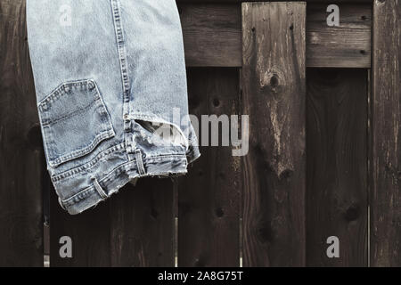 Blue Jeans outdoor auf verwitterte Holzgeländer verblasst. Stockfoto