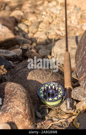 Ein Rod und Reel sitzen bereit für die Fischerei auf den Felsen entlang eines Flusses im Norden von Colorado. Stockfoto