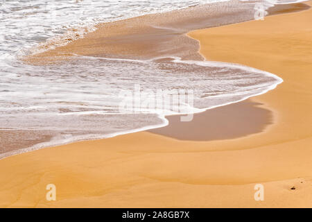 Ständig wandelnde Muster von Wellen im Sand erstellt - Peterborough, Victoria, Australien Stockfoto