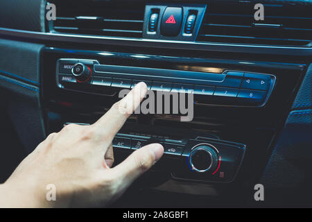 Transport- und Fahrzeugkonzept - ein Mann mit dem Auto Audio Stereo System Stockfoto