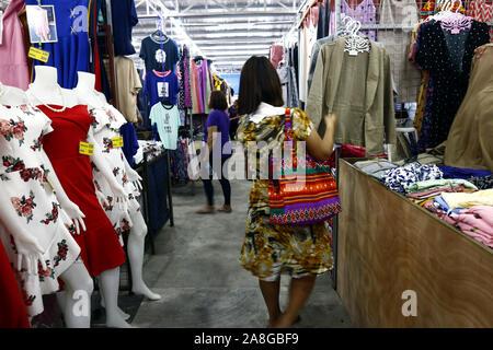 TAYTAY, Rizal, Philippinen - NOVEMBER 7, 2019: Sortiert günstige Kleidung und Schuhe auf dem Display auf einem Basar in einem beliebten Basar oder loca Abschaltdruck Stockfoto