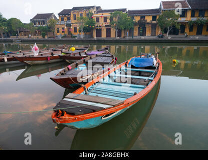 Nahaufnahme eines Wooden Fischerboot mit gemalten Auge auf dem Thu Bon Fluss in Hoi An Vietnam günstig mit goldenem Stuck riverfront Gebäude in der Stockfoto