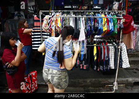 TAYTAY, Rizal, Philippinen - NOVEMBER 7, 2019: Sortiert günstige Kleidung und Schuhe auf dem Display auf einem Basar in einem beliebten Basar oder loca Abschaltdruck Stockfoto