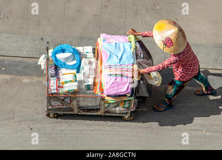 SAIGON, Vietnam, 18.Dezember 2017, vietnamesische Frau treibt einen Wagen voller Handtücher und Tücher in den Straßen von Ho Chi Minh Stadt. Stockfoto