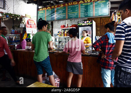 TAYTAY, Rizal, Philippinen - NOVEMBER 7, 2019: Kunden Line up gekochtes Essen in einem örtlichen Lokal oder Restaurant namens "Karinderia", die Uhr zu kaufen Stockfoto