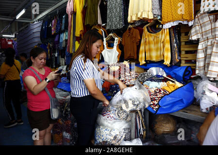 TAYTAY, Rizal, Philippinen - NOVEMBER 7, 2019: Sortiert günstige Kleidung und Schuhe auf dem Display auf einem Basar in einem beliebten Basar oder loca Abschaltdruck Stockfoto