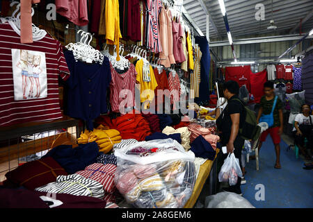 TAYTAY, Rizal, Philippinen - NOVEMBER 7, 2019: Sortiert günstige Kleidung und Schuhe auf dem Display auf einem Basar in einem beliebten Basar oder loca Abschaltdruck Stockfoto