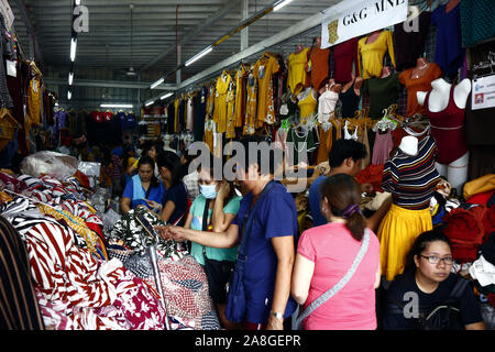 TAYTAY, Rizal, Philippinen - NOVEMBER 7, 2019: Sortiert günstige Kleidung und Schuhe auf dem Display auf einem Basar in einem beliebten Basar oder loca Abschaltdruck Stockfoto