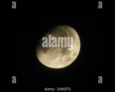 Ein helles 3-viertel Mond steht in den Nachthimmel. Stockfoto