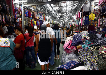 TAYTAY, Rizal, Philippinen - NOVEMBER 7, 2019: Sortiert günstige Kleidung und Schuhe auf dem Display auf einem Basar in einem beliebten Basar oder loca Abschaltdruck Stockfoto
