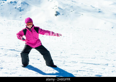 Kleine Mädchen spielen snowboard Trainer auf Schnee Stockfoto