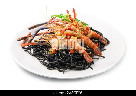 Schwarze Spaghetti scharfes Essen serviert mit gegrillten Garnelen Thai Food Gemischte italienische Fusion Style dekorieren mit geschnitzten Paprika und Frühlingszwiebeln Seitenansicht Stockfoto