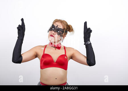 Porträt der Frau in Rot BH und schwarze Maske warten die Daumen halten. Stockfoto