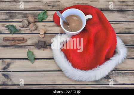 Mug Milch Schokolade in einem Weihnachtsmann Hut auf einem Holztisch Stockfoto