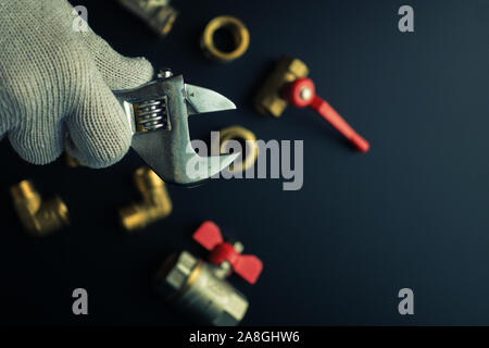 Sanitär Anlagen auf einem schwarzen Hintergrund. Ventile und Schraubenschlüssel Stockfoto