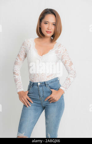 Schöne portrait asiatische Frau Braun kurze Bob trägt eine weiße Spitze Body und Blue Jeans in der Standposition mit Mode auf isolierten weißen backgroun Stockfoto