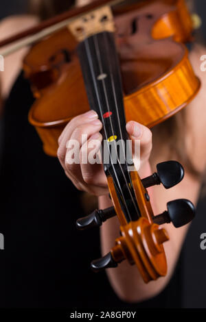 Nahaufnahme von professionellen Violine in den Händen des kleinen Mädchen spielen es auf schwarzem Hintergrund Stockfoto