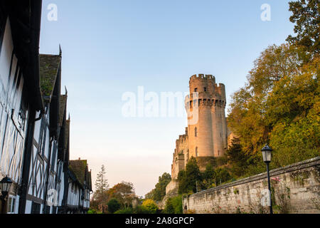 Warwick Castle bei Sonnenaufgang von Mill Street im Herbst. Warwick, Warwickshire, England Stockfoto