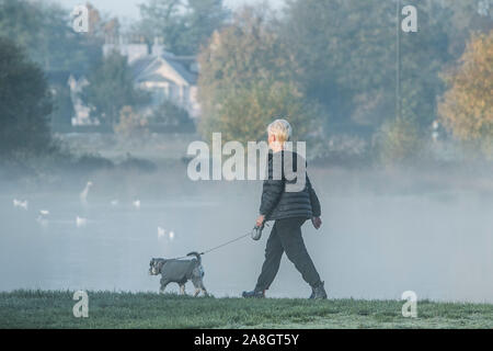 Wimbledon London, UK. 9. November 2019. Menschen durch eine dichte Schicht des frühen Morgens Nebel und Frost auf Wimbledon Common gehen wie Temperaturen unter dem Gefrierpunkt über Nacht gesunken. Amer ghazzal/Alamy leben Nachrichten Stockfoto