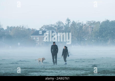 Wimbledon London, UK. 9. November 2019. Menschen durch eine dichte Schicht des frühen Morgens Nebel und Frost auf Wimbledon Common gehen wie Temperaturen unter dem Gefrierpunkt über Nacht gesunken. Amer ghazzal/Alamy leben Nachrichten Stockfoto