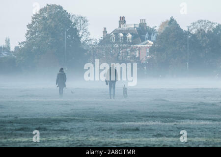 Wimbledon London, UK. 9. November 2019. Menschen durch eine dichte Schicht des frühen Morgens Nebel und Frost auf Wimbledon Common gehen wie Temperaturen unter dem Gefrierpunkt über Nacht gesunken. Amer ghazzal/Alamy leben Nachrichten Stockfoto