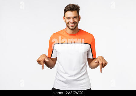 Schön frech, männliche Hispanic Sportler in Sport t-shirt, tragen Activewear, laden Sie ein Fitnessstudio Mitgliedschaft kaufen und lächelte geheimnisvoll und sehr zufrieden Stockfoto